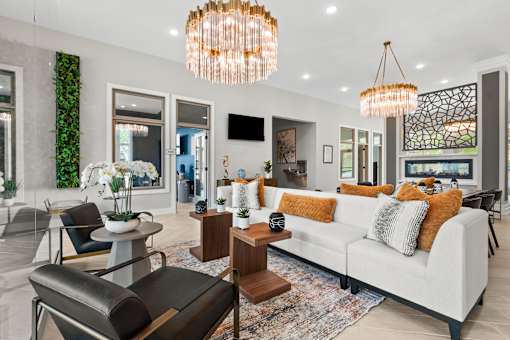 A modern living room with a white sofa and a large chandelier.