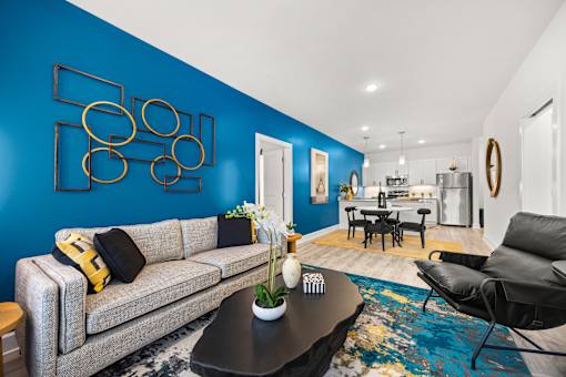 Open concept living room with blue accent wall at Ardmore at Prosperity Apartments, Tennessee, 37932