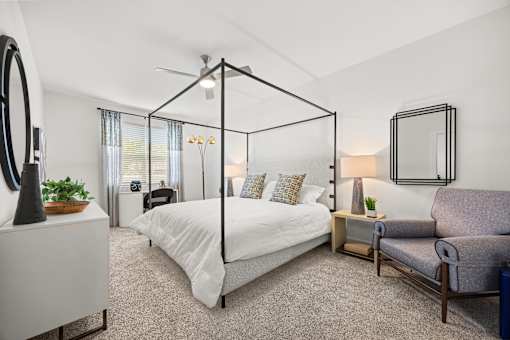 Spacious bedroom with canopy bed and sitting area at Ardmore at Prosperity Apartments, Knoxville, TN
