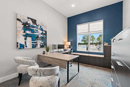 A room with a blue wall and a painting on it.