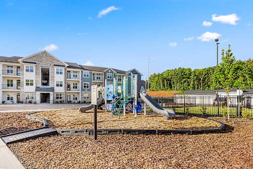 Playground with wood chip surface and apartment buildings at Ardmore at Prosperity Apartments, Tennessee