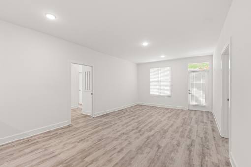 A room with wooden flooring and white walls.
