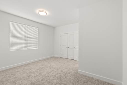 A white room with a window and a cabinet.
