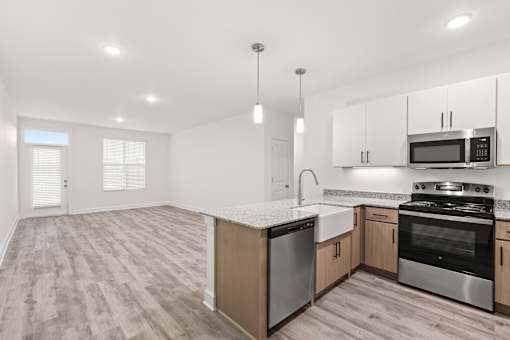 A kitchen with a refrigerator, oven, and microwave.