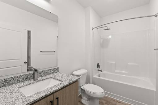 A white bathroom with a sink, toilet, and bathtub.
