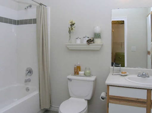 A white toilet sits next to a white sink in a bathroom.