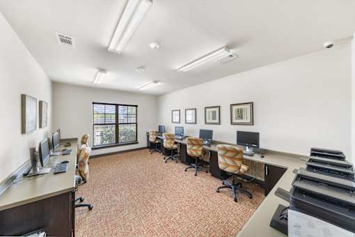 a conference room with desks and chairs and a piano