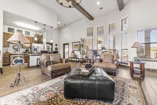 a living room with a leather ottoman and a leather couch