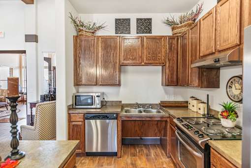 a kitchen with wooden cabinets and stainless steel appliances