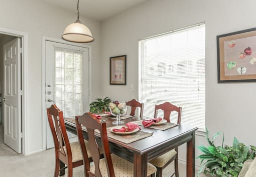 A dining room with a table set for a meal.