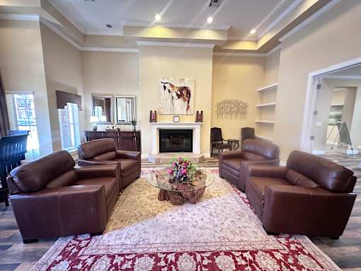 A living room with brown leather furniture and a fireplace.