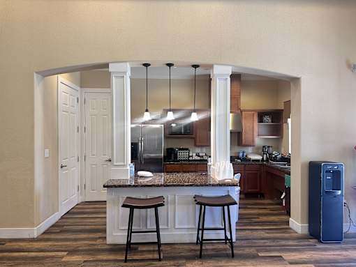 A kitchen with a bar area and a refrigerator.