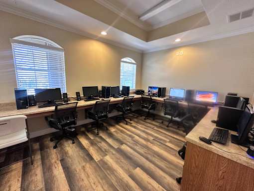 A room with a long table and multiple computer monitors.