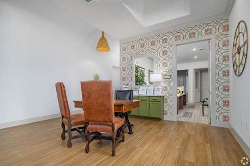 A room with a desk and chairs.