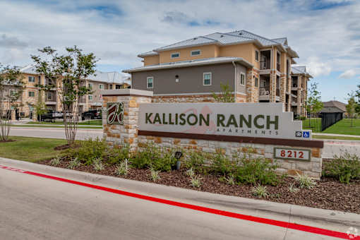 A sign for Kallison Ranch Apartments is in front of a building.