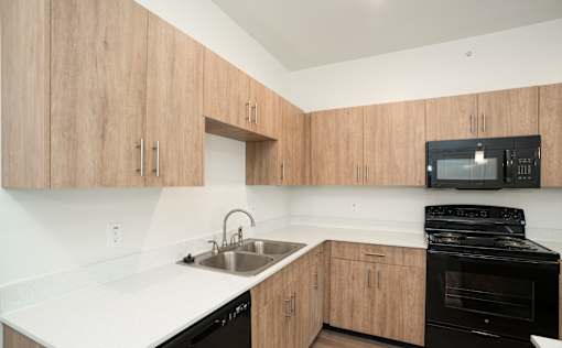 A kitchen with wooden cabinets and black appliances.