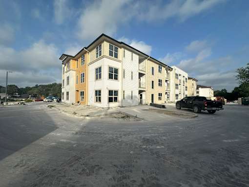 an apartment building with a car parked in a parking lot
