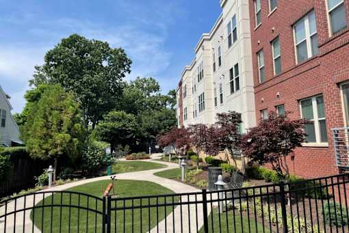 A black metal fence surrounds a green lawn.