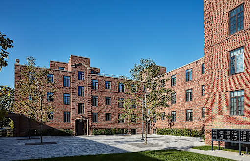 a large brick building with trees in front of it