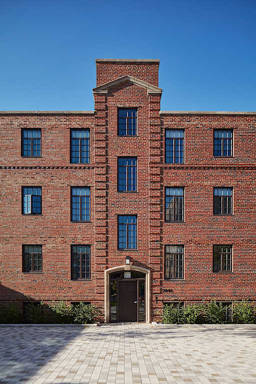 the front of a red brick building with a brown door