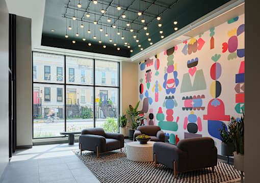 A brightly colored mural of various shapes and objects adorns the wall of a modern waiting room.