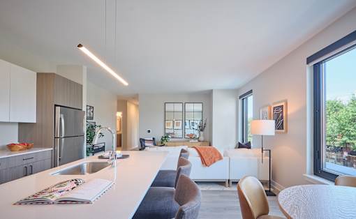 A modern kitchen with a dining area and a view of the outdoors.