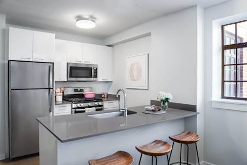 a kitchen with a island and a stainless steel refrigerator