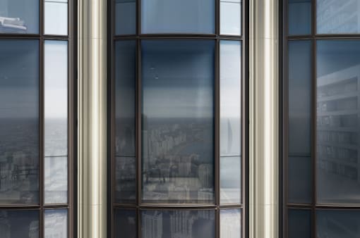 A building with a view of a cityscape reflected in its windows.
