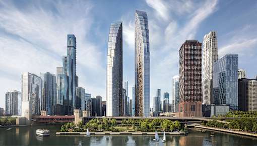 A cityscape with tall buildings and boats on the river.