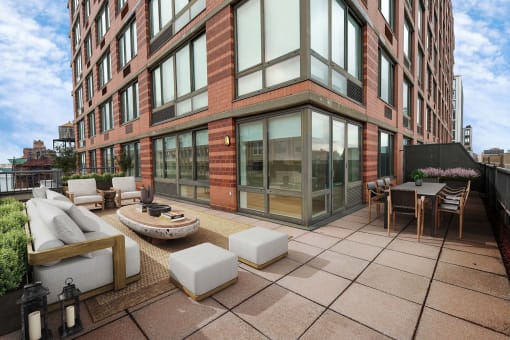 a large patio with furniture and a building in the background