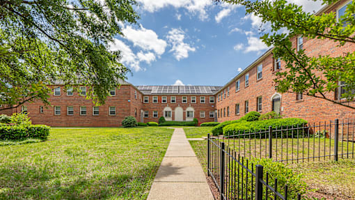 A long brick building with a walkway in front.