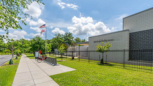 A flag is flying in front of a building with a black fence.