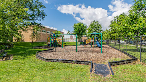A playground with a green swing set and a slide.