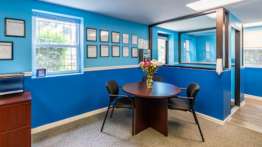 A dining room with a table and chairs.