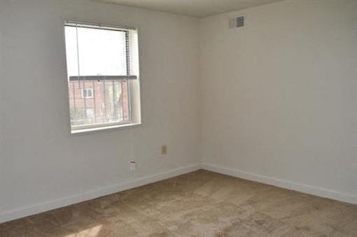 A room with a window and a wall socket.