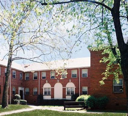 A red brick building with white trim and a white door.