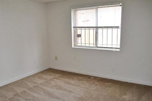 A room with a window and a tiled floor.