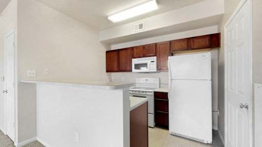 a kitchen with white appliances and wooden cabinets