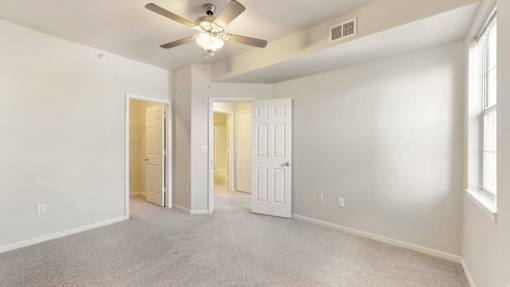 an empty living room with a ceiling fan