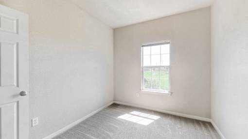 an empty room with a window and a door