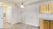 an empty kitchen with white walls and wooden cabinets