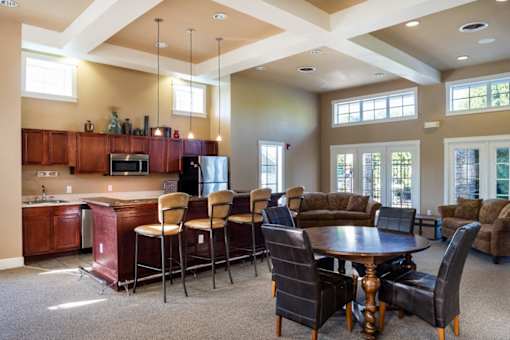 a clubhouse with a dining room and a bar with chairs