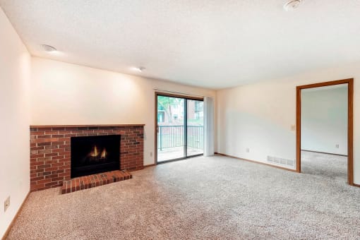 a living room with a fireplace and a door to a balcony