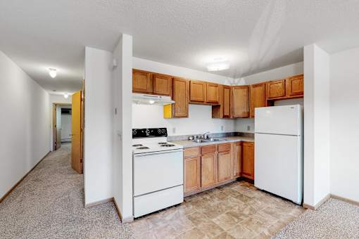 a kitchen with white appliances and wooden cabinets