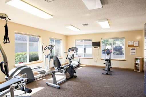a gym with exercise equipment and windows