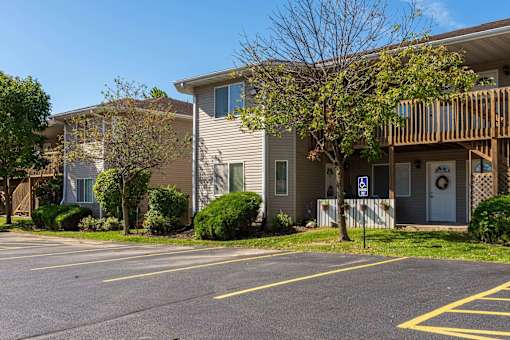 a building with a porch and a parking lot
