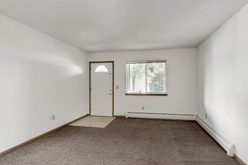 an empty room with a door and a window