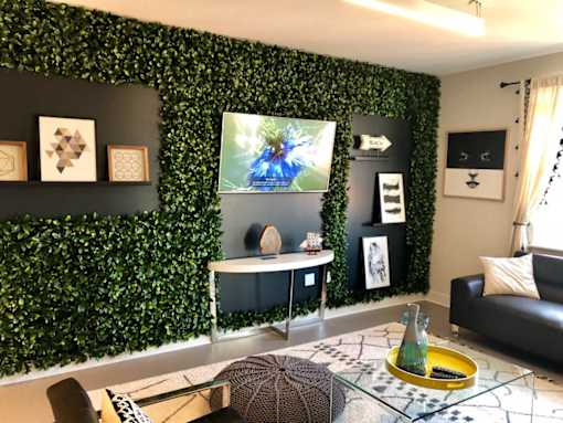 A living room with a green wall and a television at The Olivia Apartments, Carmel