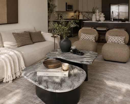 A modern living room with a white sofa, a coffee table, and a large vase.