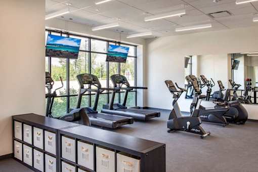A gym with treadmills, exercise bikes, and a row of storage boxes at The Olivia Apartments, Indiana